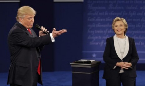 Calon presiden AS Donald Trump berbicara dengan rivalnya Hillary Clinton dalam debat kedua calon presiden di Washington University, St Louis, Ahad, 9 Oktober 2016.