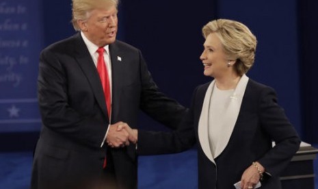 Calon presiden AS Donald Trump dan Hillary Clinton berjabat tangan usai debat capres kedua di Washington University, St Louis, Ahad, 9 Oktober 2016.