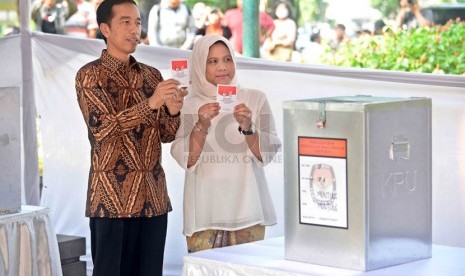  Calon Presiden nomer urut dua, Joko Widodo bersama istri, Iriana menggunakan hak suaranya di TPS 18 Kecamatan Menteng, Kelurahan Menteng, Jakarta Pusat, Rabu (9/7).(Republika/Agung Supriyanto)