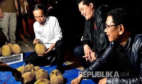   Calon presiden nomor urut 01 Joko Widodo (Jokowi) bersama Ketua TKN Erick Thohir membeli buah durian di pinggir jalan kota Dumai, usai berkampanye di Taman Bukit Gelanggang, Kelurahan Teluk Binjai, Kecamatan Dumai Timur, Kota Dumai, Selasa (26/3) malam. 