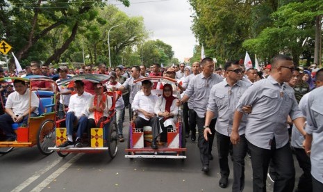 Calon presiden nomor urut 01 Joko Widodo didampingi  Iriana Jokowi bersama Ketua Dewan Pengarah Tim Kampanye Nasional Jokowi-Ma'ruf Jusuf Kalla dan Ibu Mufidah Jusuf Kalla dan Ketua TKN Erick Thohir naik becak menuju Lapangan Karebosi, Makassar, Ahad (31/3).