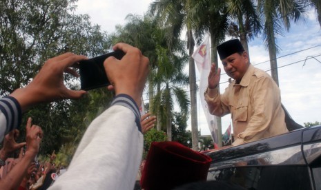 Calon Presiden nomor urut 02 Prabowo Subianto menyapa pendukungnya dari atas mobil saat berkampanye di Serang, Banten, Sabtu (16/3/2019).