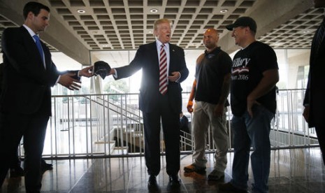 Calon presiden Partai Republik Donald Trump berbincang dengan veteran militer di Milwaukee County War Memorial Cente, Milwaukee, Wisconsin, Selasa, 16 Agustus 2016. 