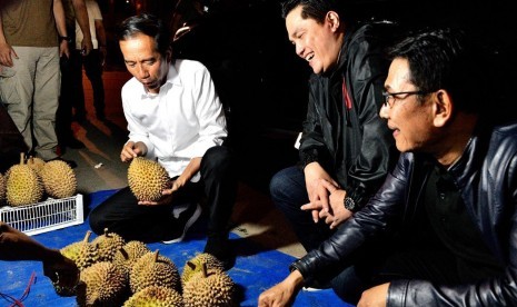 Calon presiden pejawat Joko Widodo memborong durian dari pedang pinggir jalan di Dumai.