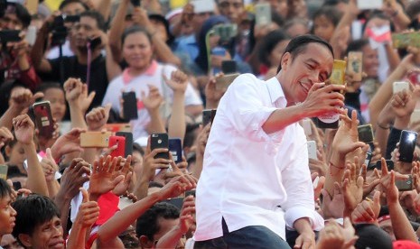 Calon Presiden petahana nomor urut 01 Joko Widodo berswafoto dengan massa pendukungnya saat melakukan kampanye terbuka di kota Dumai, Dumai, Riau, Selasa (26/3).