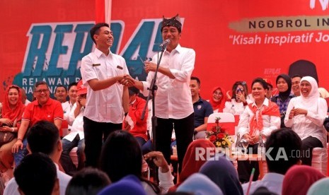 Calon Presiden petahana nomor urut 01 Joko Widodo (kanan) berbincang dengan salah satu relawan Pengusaha Muda Nasional (Repnas) saat menggelar kampanye Ngopi (ngobrol Inspirasi) di Banyuwangi, Jawa Timur, Senin (25/3/2019).