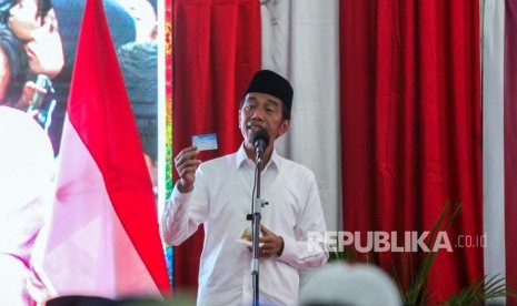 Calon Presiden petahana nomor urut 01 Joko Widodo menunjukkan kartu Pra Kerja saat berpidato dalam kampanye terbuka di Lhokseumawe, Aceh, Selasa (26/3/2019). 