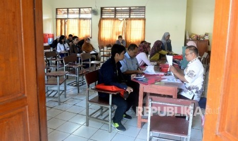  Calon siswa dan Orang tua wali melakukan pendaftaran ulang sebelum kegiatan belajar mengajar di SMA 6 Depok, Jawa Barat, Rabu (12/7). 