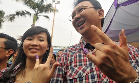 Calon Wakil Gubernur DKI Jakarta, Basuki Tjahaja Purnama atau Ahok (kanan), bersama istrinya Veronica (kiri) menunjukkan jari mereka yang telah diberi tanda tinta usai memberikan hak suaranya di Tempat Pemungutan Suara (TPS) 059 Kelurahan Pluit, Penjaringa