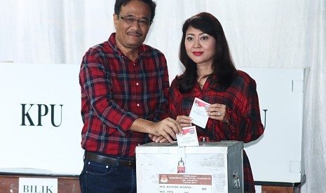 Calon Wakil Gubernur DKI Jakarta Nomor Urut Dua, Djarot Saiful Hidayat (kiri) bersama istri, Happy Farida (kanan) memasukkan surat suara saat menggunakan hak pilih di TPS 8, Kuningan, Jakarta, Rabu (15/2). 