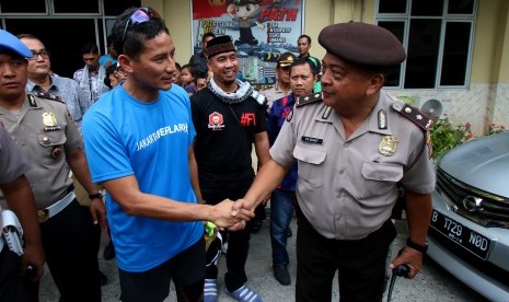 Calon Wakil Gubernur DKI Jakarta nomor urut tiga, Sandiaga Uno (kiri) meninggalkan kantor polisi usai menjalani pemeriksaan di Polsek Tanah Abang, Jakarta, Jumat (17/3). 