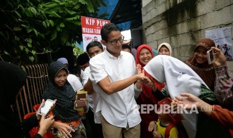 Calon Wakil Gubernur DKI Jakarta Sandiaga S. Uno menyapa warga saat kampanye di Kampung Dukuh, Kramat Jati, Jakarta, Kamis (24/11).