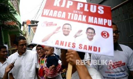 Calon Wakil Gubernur DKI Jakarta Sandiaga S. Uno menyapa warga saat kampanye di Kampung Dukuh, Kramat Jati, Jakarta, Kamis (24/11).