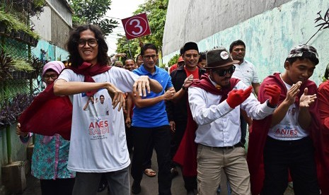 Calon Wakil Gubernur DKI Jakarta Sandiaga Salahuddin Uno menari untuk menghibur warga setibanya di kelurahan Mampang, Jakarta, Rabu (17/1). 