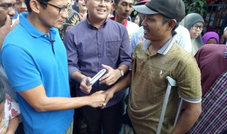 Calon Wakil Gubernur DKI Jakarta, Sandiaga Salahuddin Uno, mendengarkan keluhan seorang warga penyandang difabel, Heryanto, di Jalan Swadaya RW07, Jatinegara, Jakarta Timur, Sabtu (4/2). 