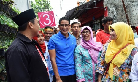 Calon Wakil Gubernur DKI Jakarta Sandiaga Uno (kedua kiri) menyapa warga saat mengunjungi kelurahan Mampang, Jakarta, Rabu (17/1).