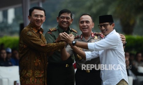 Calon Wakil Gubernur nomor urut 3 Sandiaga Uno (kanan) bersama Kapolda Metro Jaya M. Iriawan (kedua kanan), Pangdam Jaya Jaswandi (kedua kiri), dan Calon Gubernur nomor urut 2 Basuki Tjahaja Purnama (kiri) berjabat tangan saat pembacaan deklarasi damai di silang Monas, Jakarta, Senin (17/4). 