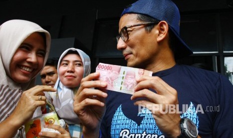 Calon Wakil Presiden nomer urut 02 Sandiaga Uno (kanan) menerima titipan uang sebesar Rp. 100ribu untuk dana kampanye dari seorang warga seusai melakukan diskusi Ruang Sandi di Tangerang, Banten, Selasa (15/1/2019). 