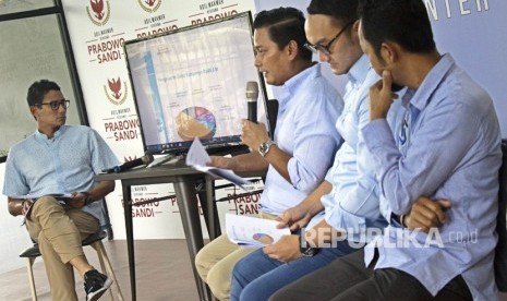 Calon Wakil Presiden nomor urut 02 Sandiaga Uno (kiri) mendengarkan Bendahara BPN Prabowo-Sandi Thomas Djiwandono (kedua kiri), Wakil Bendaraha BPN Prabowo-Sandi Dimas (kedua kanan) dan Tim Auditor BPN Prabowo-Sandi Heru (kanan) menyampaikan presentasi laporan dana kampanye di media center pemenangan Prabowo-Sandi di Jalan Sriwijaya, Jakarta, Senin (31/12/2018). 