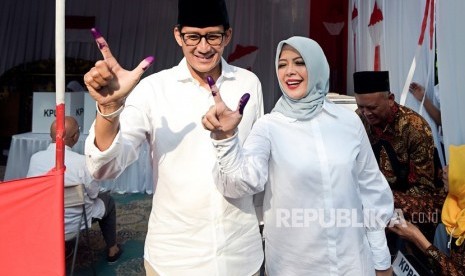 Calon Wakil Presiden nomor urut 02 Sandiaga Uno (kiri) dan istri Nur Asia Uno (kanan menunjukkan jari yang telah dicelup tinta usai melakukan pencoblosan dalam Pemilu 2019 di TPS 02, Jakarta, Rabu (17/4/2019).