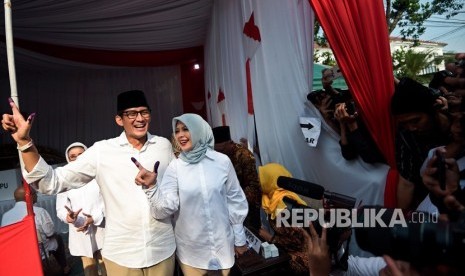 Calon Wakil Presiden nomor urut 02 Sandiaga Uno (kiri) dan istri Nur Asia Uno (kanan menunjukkan jari yang telah dicelup tinta usai melakukan pencoblosan dalam Pemilu 2019 di TPS 02, Jakarta, Rabu (17/4/2019).