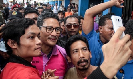 Calon Wakil Presiden nomor urut 02 Sandiaga Uno (tengah) menyapa pedagang ketika berkunjung ke Pasar Larangan, Sidoarjo, Jawa Timur, Selasa (1/1/2019). 