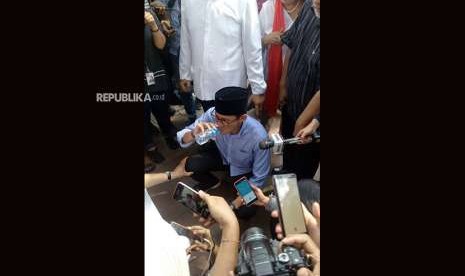 Calon wakil presiden Sandiaga Uno mengambil minum usai berhasil keluar dari kerumunan massa pendukungnya di depan gerbang Komisi Pemilihan Umum (KPU) di Jalan Imam Bonjol, Jakarta Pusat, Jumat (10/8). 