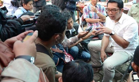   Calon Wali Kota Bandung, Ridwan Kamil menjawab pertanyaan wartawan saat mengunjungi Sentra Rajut di Binongjati, Bandung, Selasa (2/4).    (Republika/Edi Yusuf)