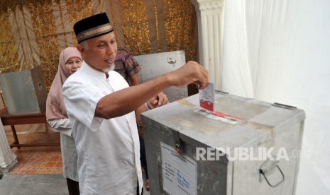 Calon Wali Kota Padang, Mahyeldi bersama istri, menggunakan hak pilih di TPS 7, Parupuk Tabing, Padang, Sumatera Barat, Rabu (27/6).