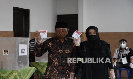 Calon Wali Kota Solo nomor urut dua Bagyo Wahyono (kiri) dan istrinya Agustini Pribadi Ningsih (kanan) menunjukkan surat suara saat menggunakan hak pilih di TPS 8, Penumping, Solo, Jawa Tengah, Rabu (9/12/2020). Pasangan calon Wali Kota dan Wakil Wali Kota Solo jalur perseorangan atau non partai Bagyo Wahono dan FX Supardjo?bersaing dalam merebut suara dengan pasangan Gibran Rakabuming Raka-Teguh Prakosa?pada Pilkada Kota Solo 2020.