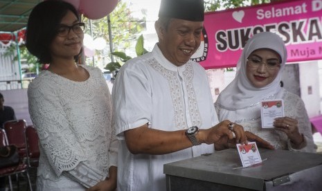 Calon Wali Kota Yogyakarta Petahana Haryadi Suyuti (tengah) didampingi istri Tri Kirana Muslidatun (kanan) dan putri Karina Arifiani (kiri) menggunakan hak pilih di TPS 15 Kelurahan Muja Muju; Umbulharjo; DI Yogyakarta, Rabu (15/2).