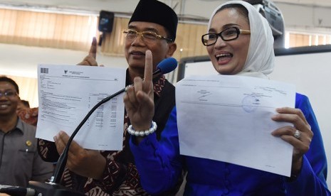 Calon Walikota Surabaya Rasiyo (kiri) dan pasangannya calon Wakil Walikota Surabaya Lucy Kurniasari (kanan) menunjukkan laporan harta kekayaannya ketika mengikuti pembekalan dan deklarasi calon kepala daerah dan penyelenggara pilkada Jatim di Unesa, Suraba