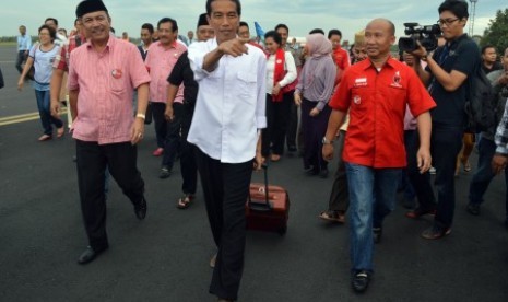 Capres dari PDI perjuangan Joko Widodo (tengah) didampingi Pasangan Calon Gubernur Lampung Berlian Tihang (kiri) dan Mukhlis Basri (kanan) setibanya di Bandara Radin Inten II Lampung Selatan, Lampung, Jumat (21/3). Jokowi dijadwalkan menghadiri kampanye te