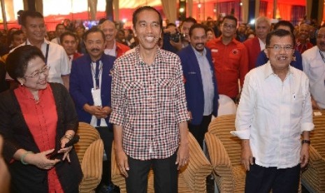 Capres Joko Widodo alias Jokowi (tengah) yang didampingi Cawapres Jusuf Kalla (kanan) bersama dengan Ketua Umum PDIP Megawati Soekarnoputri saat menghadiri acara Rapat Kerja Nasional (Rakernas) II Partai NasDem di Ancol, Jakarta, Selasa (27/5).