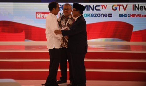 Capres nomor urut 01 Joko Widodo (kiri) berjabat tangan dengan Capres nomor urut 02 Prabowo Subianto (kanan) disaksikan Ketua KPU Arief Budiman (tengah) saat debat capres 2019 putaran kedua di Hotel Sultan, Jakarta, Ahad (17/2/2019).