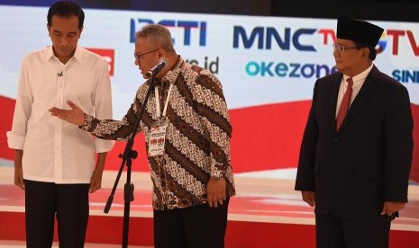 Capres nomor urut 01 Joko Widodo (kiri) dan Capres nomor urut 02 Prabowo Subianto (kanan) bersiap memulai debat capres 2019 disaksikan Ketua KPU Arief Budiman (tengah) di Hotel Sultan, Jakarta, Ahad (17/2/2019).