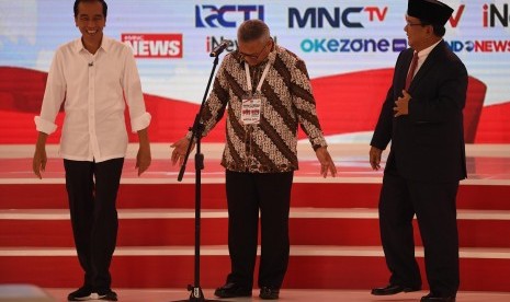 Capres nomor urut 01 Joko Widodo (kiri) dan Capres nomor urut 02 Prabowo Subianto (kanan) bersiap memulai debat capres 2019 disaksikan Ketua KPU Arief Budiman (tengah) di Hotel Sultan, Jakarta, Ahad (17/2/2019).