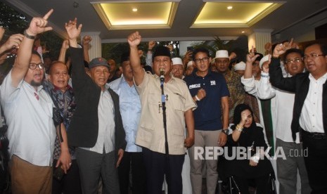 Capres nomor urut 02 Prabowo Subianto (tengah) bersama Cawapres Sandiaga Uno dan petinggi partai pendukung mengangkat tangan saat mendeklarasikan kemenangannya pada Pilpres 2019 kepada awak media di kediaman Kertanegara, Jakarta, Kamis (18/4/2019). 