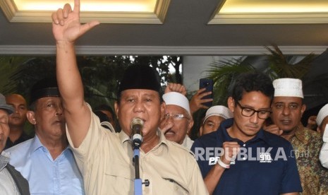 Capres nomor urut 02 Prabowo Subianto (tengah) bersama Cawapres Sandiaga Uno dan petinggi partai pendukung mengangkat tangan saat mendeklarasikan kemenangannya pada Pilpres 2019 kepada awak media di kediaman Kertanegara, Jakarta, Kamis (18/4/2019). 