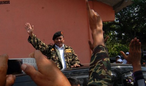   Capres nomor urut satu, Prabowo Subianto (tengah) menyapa pendukung dan simpatisan saat menghadiri apel Ansor Serba Guna (Banser) untuk Indonesia bangkit di Lapangan Puri, Mojokerto, Jawa Timur, Selasa (24/6). (Antara/Syaiful Arif)