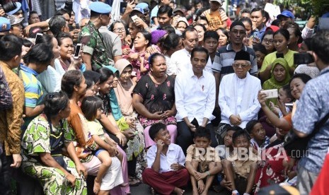 Capres petahana Joko Widodo dan cawapres Ma'ruf Amin menyapa warga usai menyampaikan pidato kemenangannya sebagai Presiden Republik Indonesia periode 2019-2024 di Kampung Deret, Tanah Tinggi, Johar Baru, Jakarta Pusat, Selasa (21/5/2019). 