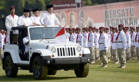   Capres Prabowo Subianto (kanan) didampingi Cawapres Hatta Rajasa (kiri) dan Ketua Umum Golkar Aburizal Bakrie (tengah) memeriksa pasukan saat upacara peringatan HUT ke-69 Kemerdekaan RI di Lapangan Nusantara Polo Club, Cibinong, Jabar, Ahad (17/8). (Anta