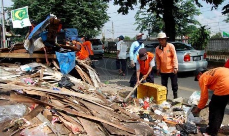  Sejumlah petugas kebersihan membersihkan sampah yang berserakan di pinggir Jalan I Gusti Ngurah Rai, Klender, Jakarta Timur, Selasa (4/3). (foto : Raisan Al Farisi)