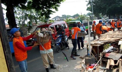  Sejumlah petugas kebersihan membersihkan sampah yang berserakan di pinggir Jalan I Gusti Ngurah Rai, Klender, Jakarta Timur, Selasa (4/3). (foto : Raisan Al Farisi)