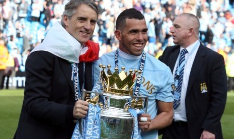 Carlos Tevez dan Roberto Mancini merayakan gelar liga Primer Inggris. Tevez dikabarkan salah satu pemain yang akan dijual City musim depan