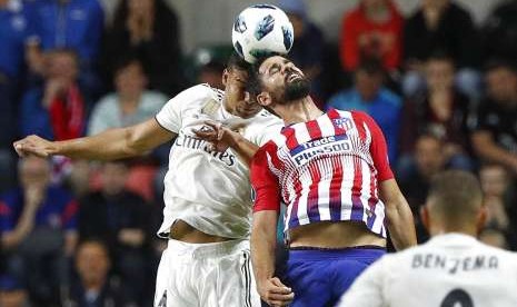 Casemiro (kiri) berduel dengan Diego Costa.