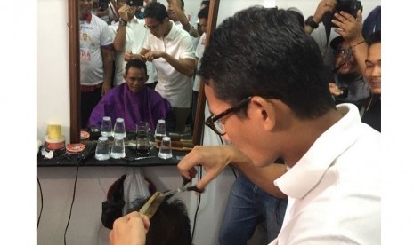 Cawagub DKI, Sandiaga Uno saat mencoba menjadi 'tukang cukur' kegiatan cukur rambut gratis di 100 titik di Jakarta.