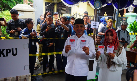 Cawagub Jabar Akhmad Syaikhu bersama istri menyoblos di TPS 76 Komplek Antara, Pondokgede, Kota Bekasi Rabu (27/6).