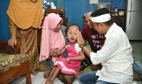 Cawagub Jabar Dedi Mulyadi (kemeja putih) saat menjenguk Suci (9 tahun), pengidap hidrosefalus di Kelurahan Medan Satria, Kecamatan Medan Satria, Kota Bekasi, Senin (19/3).  