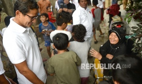 Cawagub nomer urut tiga Sandiaga S Uno menyapa warga sebelum melakukan sosialisasi warga di kawasan Kebon Melati, Tanah Abang, Jakarta Pusat, Senin (26/12). 